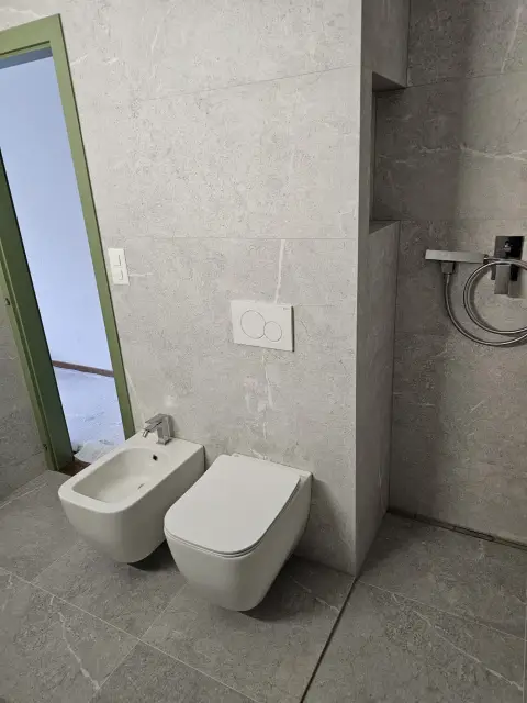 WC suspendu et bidet, carrelage marbre gris, niche de douche