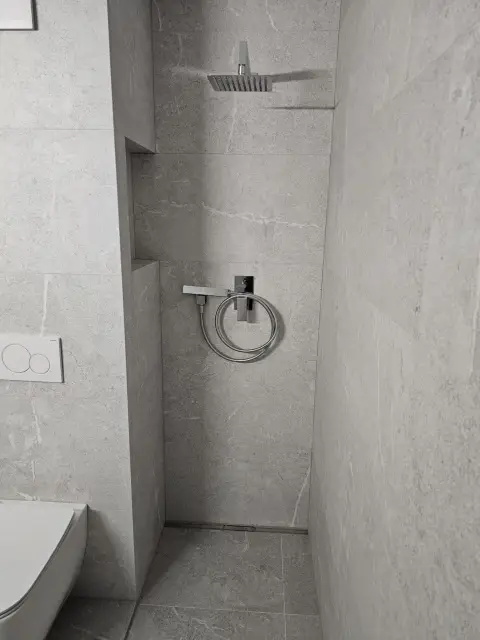 Douche à l'italienne, niche carrelée grise, robinetterie encastrée