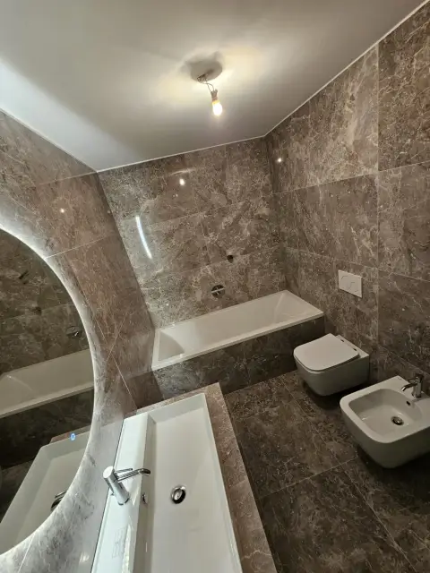 Salle de bain en marbre brun avec baignoire, WC et bidet