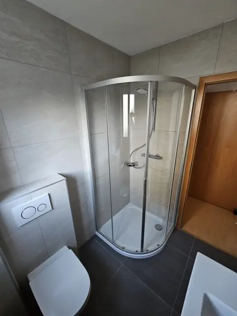 Douche d'angle en quart de rond avec paroi vitrée