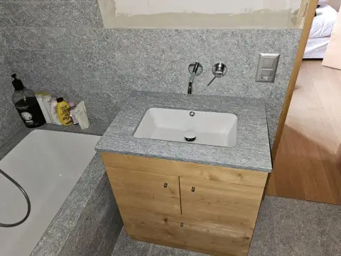 Vasque simple en granit près de la baignoire