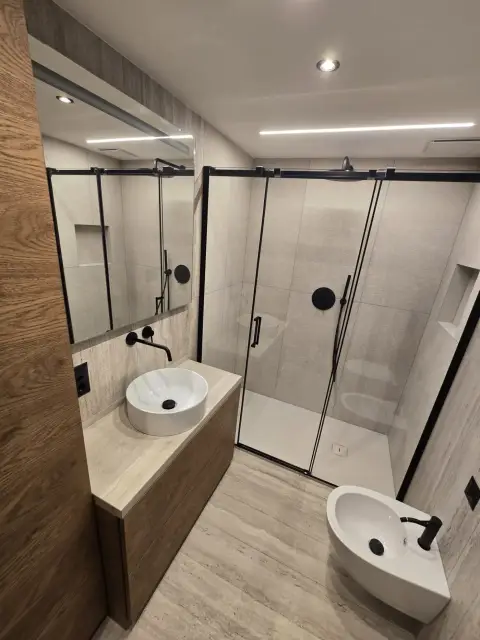 Douche noire, vasque ronde blanche, WC et bidet suspendus