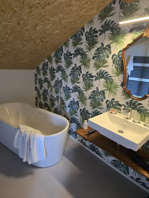 Baignoire îlot, papier peint tropical, vasque suspendue